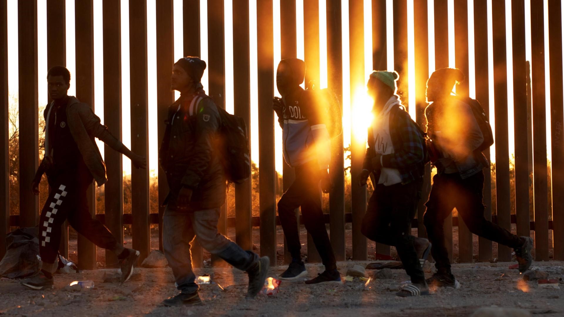 Migrantes xunto ao muro na fronteira dos EUA e México en Lukeville, Arizona (EFE/Allison Dinner)