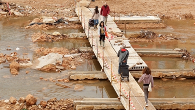 Varias persoas cruzan unha pasarela no barranco do Poio, en Picanya. EFE/Villar López