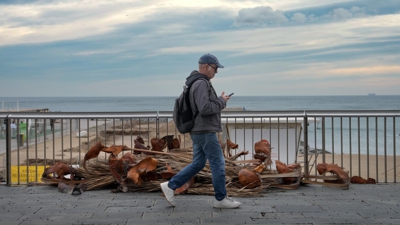 Un mozo pasea pola Barceloneta este mércores (EFE/ Enric Fontcuberta)