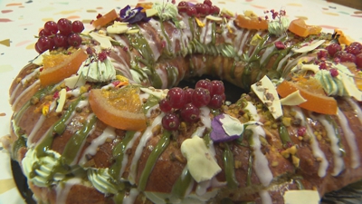 Un roscón recheo de pistachos e cuberto de bagas e de flores