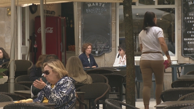 Unha camareira atende unha concorrida terraza da capital