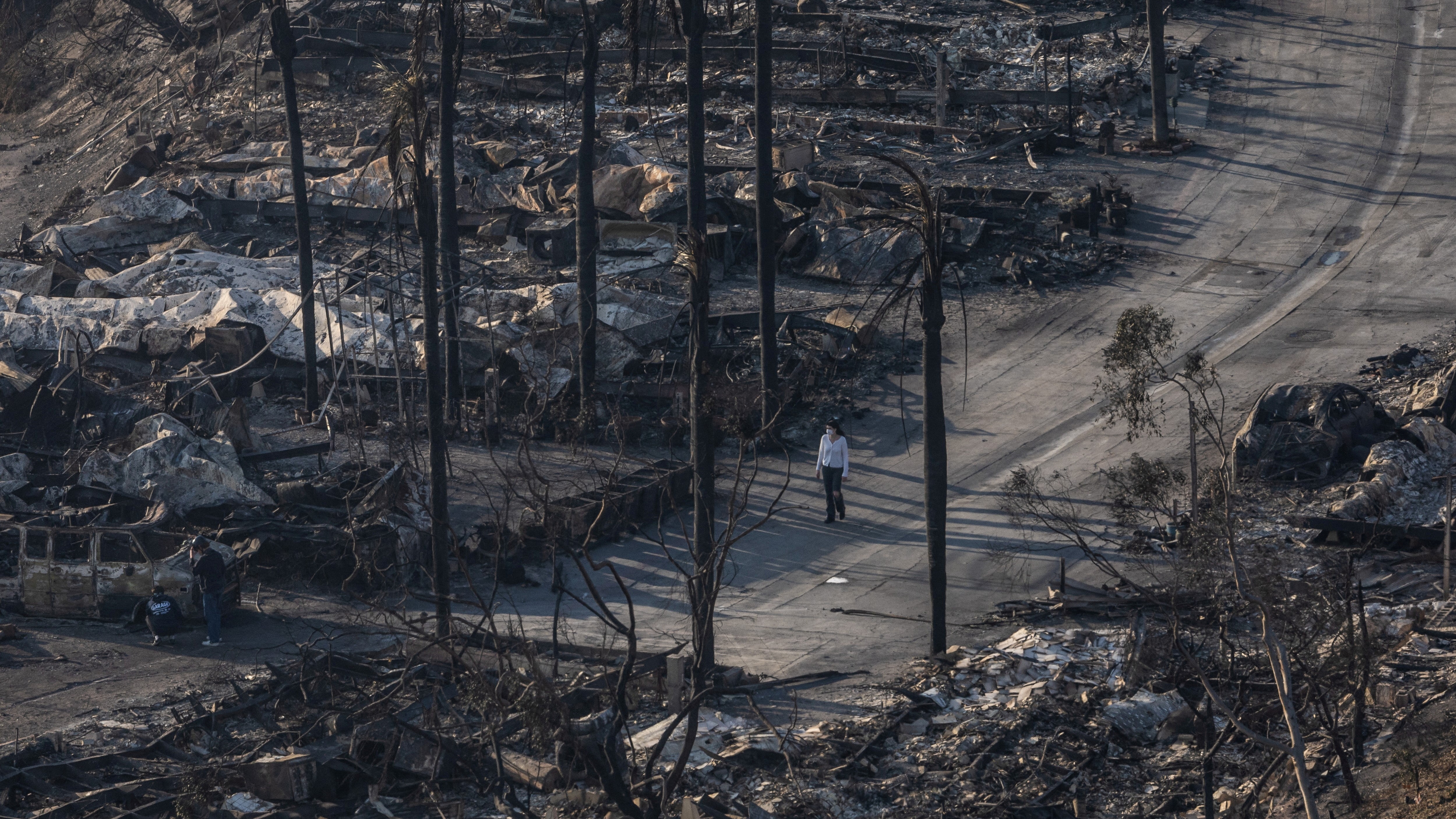 Unha muller camiña nun barrio arrasado en Pacific Palisades. REUTERS/Carlos Barria