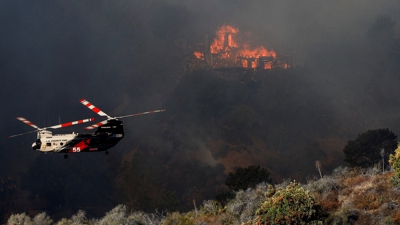 Un helicóptero loita contra o lume en Mandeville Canyon. REUTERS/Shannon Stapleton