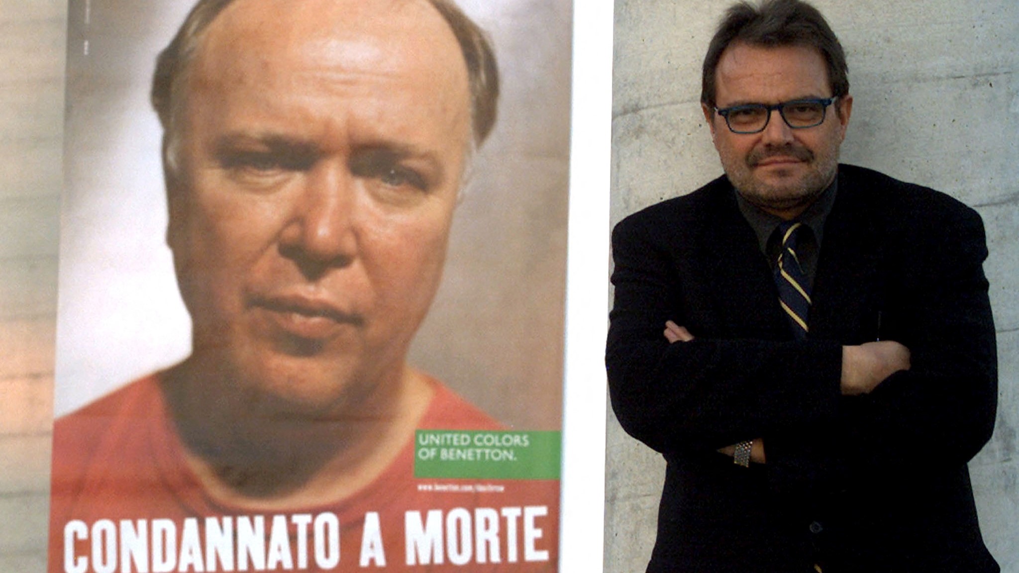 Oliviero Toscani posa, ano 2000, xunto a un dos seus carteis para Benetton coa imaxe dun preso norteamericano condenado a morte (Reuters)